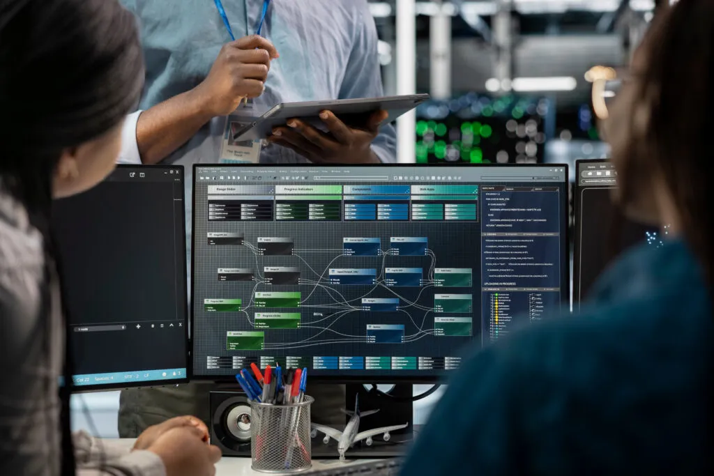 Equipo revisando en varias pantallas un diagrama de flujos de datos entre sistemas