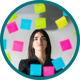 Mujer frente a una pared de notas adhesivas de colores priorizando oportunidades